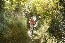 Giovane donna in mountain bike su un sentiero — Foto stock