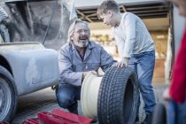 Man and boy changing car tire — Stock Photo