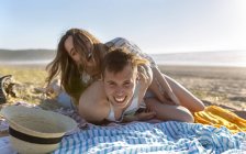 Молодая пара веселится на пляже — стоковое фото