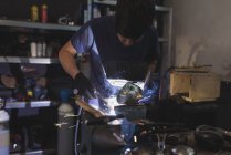 Forger welding metal in workshop — Stock Photo