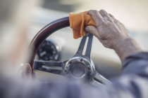 Hombre mayor pulir el volante de un coche - foto de stock