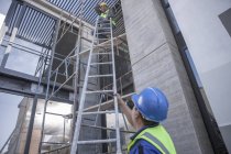 Two construction workers on scaffolding working on construction site — Stock Photo