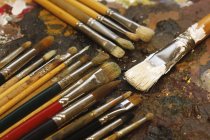 Différents pinceaux sur la palette de l'artiste — Photo de stock