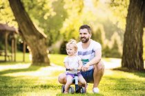 Padre e sua figlioletta con macchinina in un parco — Foto stock