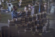 Male cooper piling wine barrels — Stock Photo