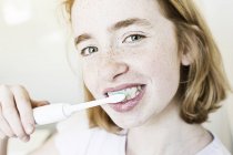 Portrait of smiling girl brushing teeth — Stock Photo