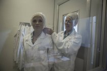 Deux techniciens de laboratoire revêtent des vêtements de protection stériles — Photo de stock