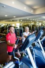 Uomo anziano e donna matura in palestra — Foto stock