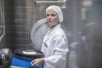 Lab technician in pharmaceutical plant in front of tanks — Stock Photo