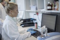 Mujer joven que trabaja en la computadora en el laboratorio - foto de stock