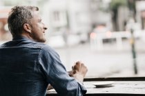 Mature man sitting in cafe — Stock Photo