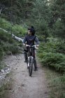 Mountainbiker sul sentiero forestale con una pausa — Foto stock