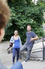 Smiling friends meeting on stairs in park — Stock Photo