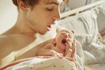 Father imitating yawn of his newborn baby — Stock Photo