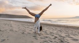 Bela jovem mulher na praia, girando roda — Fotografia de Stock