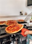 Closeup of chief preparing homemade pizzas at kitchen — Stock Photo