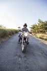Man riding motorbike on country road — Stock Photo