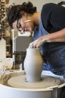 Mujer trabajando con arcilla en un taller de cerámica - foto de stock