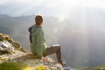 Escursionista seduto in cima godendo il tramonto — Foto stock
