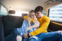 Coppia innamorata coccole sul sedile posteriore di una macchina — Foto stock