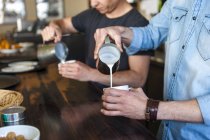 Due uomini che preparano caffè con latte in un caffè — Foto stock