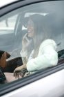Femme d'affaires souriante sur téléphone portable dans la voiture — Photo de stock