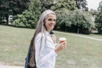 Жінка з кави до йти прогулянки в парку — стокове фото
