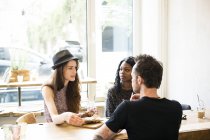 Friends meeting in cafe, eating and having fun — Stock Photo