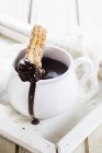 Churros bisquit with hot chocolate in white jag — Stock Photo