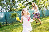 Little girl having fun with water bombs in the garden — Stock Photo