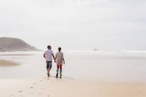 Зрелая пара гуляющая по пляжу — стоковое фото