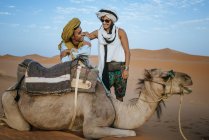 Берберські чоловік із жінкою Туристична з верблюдах в пустелі — стокове фото