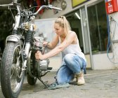 Donna che ripara moto — Foto stock