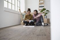 Pareja sentada en el piso de nuevo plano elegir entre muestras de color - foto de stock