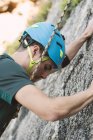 Close-up of young man climbing a rock wall — Stock Photo