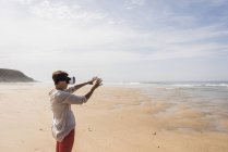Mujer con gafas de realidad virtual en Finistere of Brittany, Península de Crozon, Francia - foto de stock