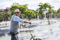 Homme âgé souriant avec vélo pliant — Photo de stock