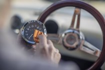 Hombre mayor pulido tacómetro de un coche - foto de stock