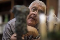Homem caucasiano sênior inspecionando bronze fundido — Fotografia de Stock
