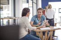 Uomo e donna che parlano in un caffè con tablet digitale — Foto stock