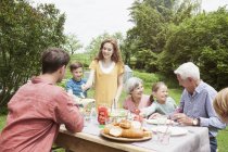 Щасливі кавказькі розширені сімейні обіди в саду — стокове фото