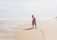 Зрелый мужчина с женой на спине на пляже — стоковое фото