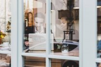 Joven hombre de negocios y mujer usando el ordenador portátil en un café - foto de stock