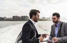 Zwei Geschäftsleute im Gespräch auf der Fähre auf dem East River, New York City, USA — Stockfoto