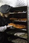 Мужчина смотрит на свежекопченый стейк лосося в коптильне — стоковое фото