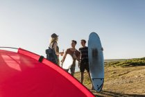Drei Freunde mit Surfbrettern campieren am Meer — Stockfoto