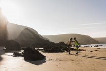 Giovane coppia che si estende sulla spiaggia, Francia, penisola di Crozon — Foto stock