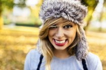 Ritratto di giovane donna sorridente con cappello di pelliccia — Foto stock