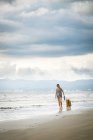 Мексика, Nayarit, молода жінка вигулює собаку золотистий ретрівер на пляжі — стокове фото