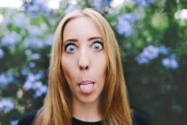 Ritratto di una donna bionda che sporge la lingua — Foto stock